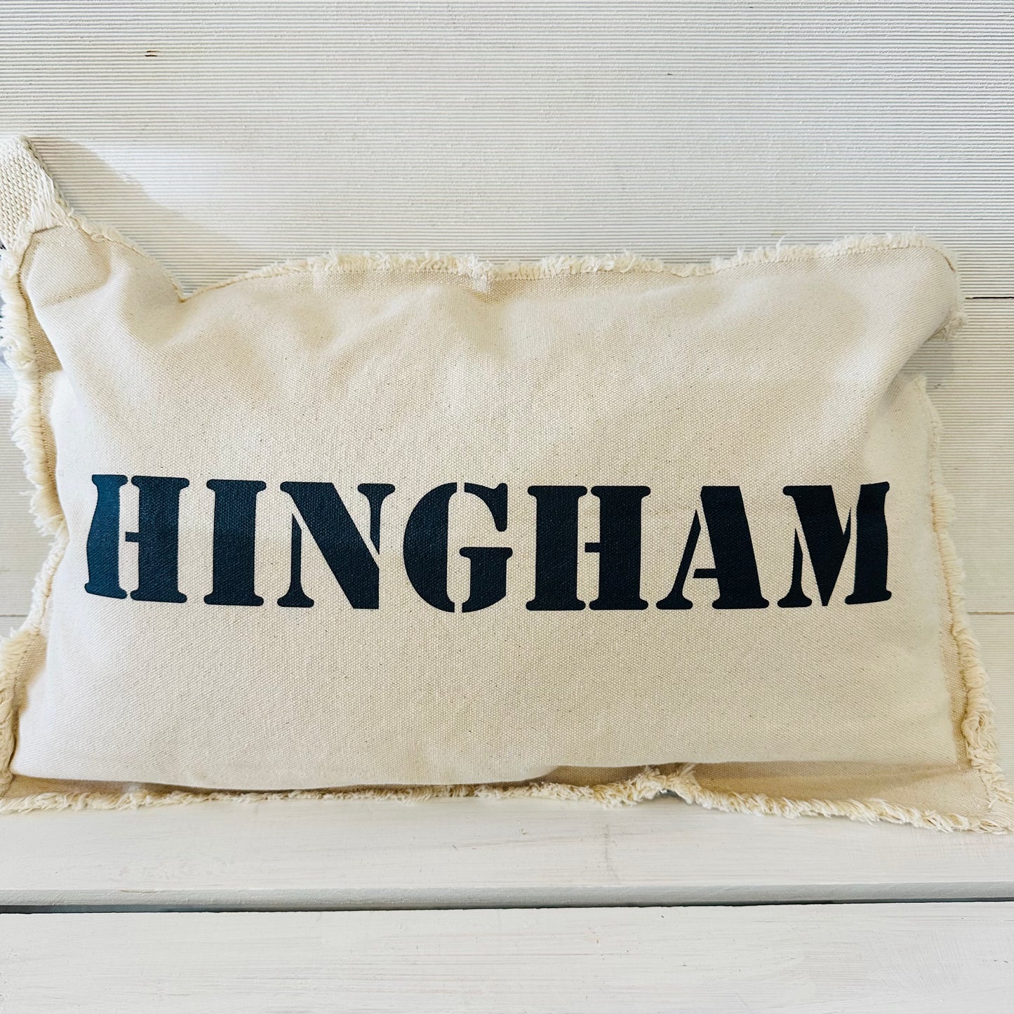white pillow with higham on it in navy