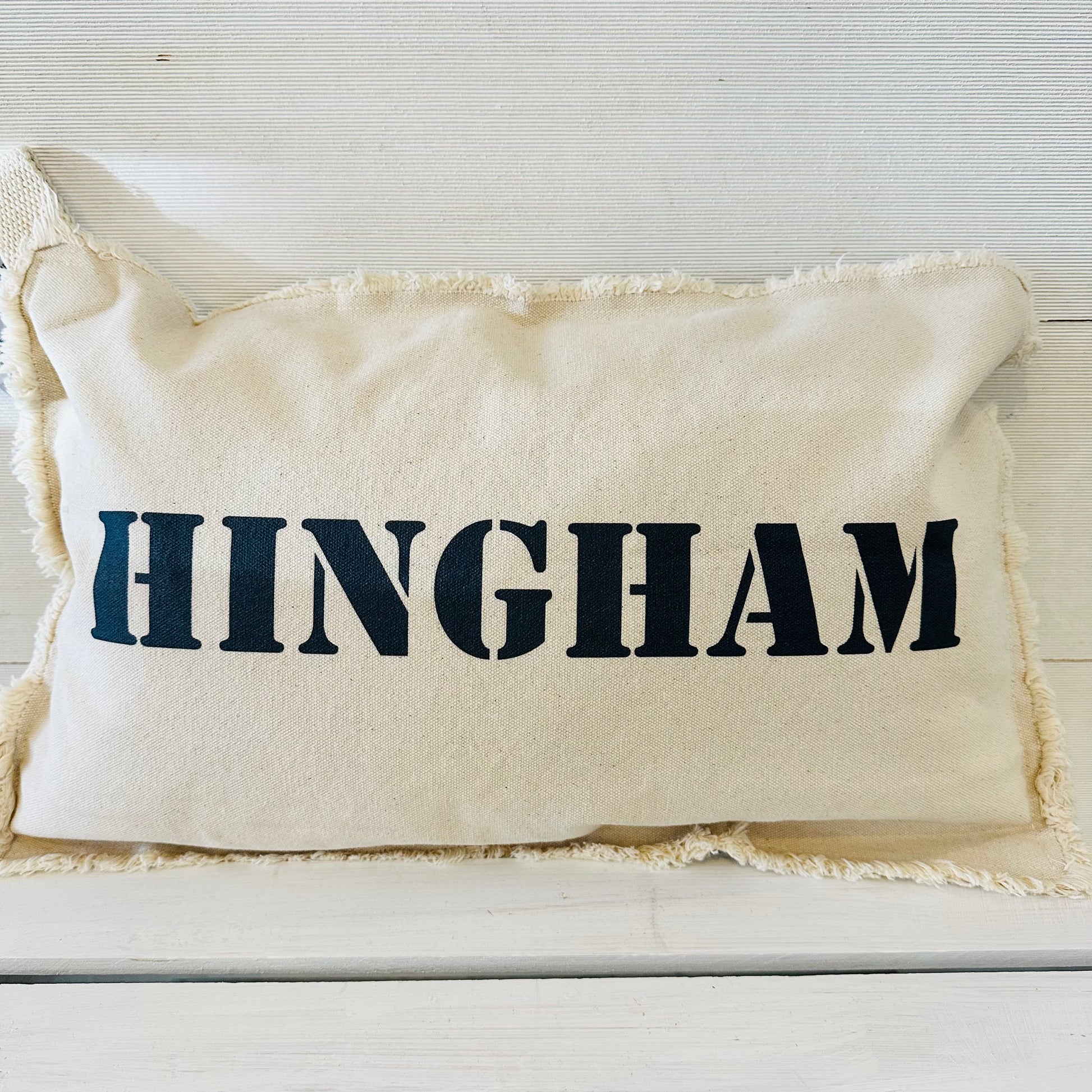 white pillow with higham on it in navy