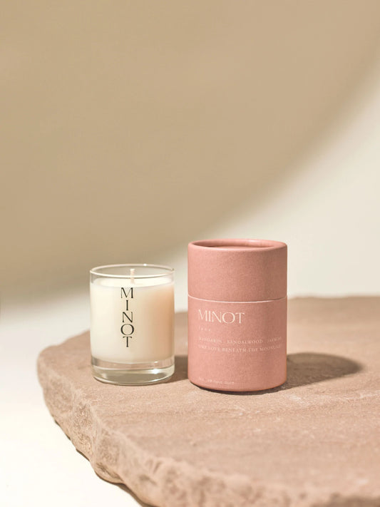 minot candle on and candle container with neutral background