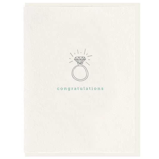 White card with gray wedding ring in the middle that has teal writing under it.