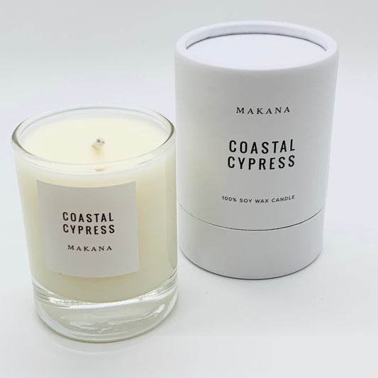Coastal Cypress Candle = glass jar with white label black writing.  packaged candle in background
