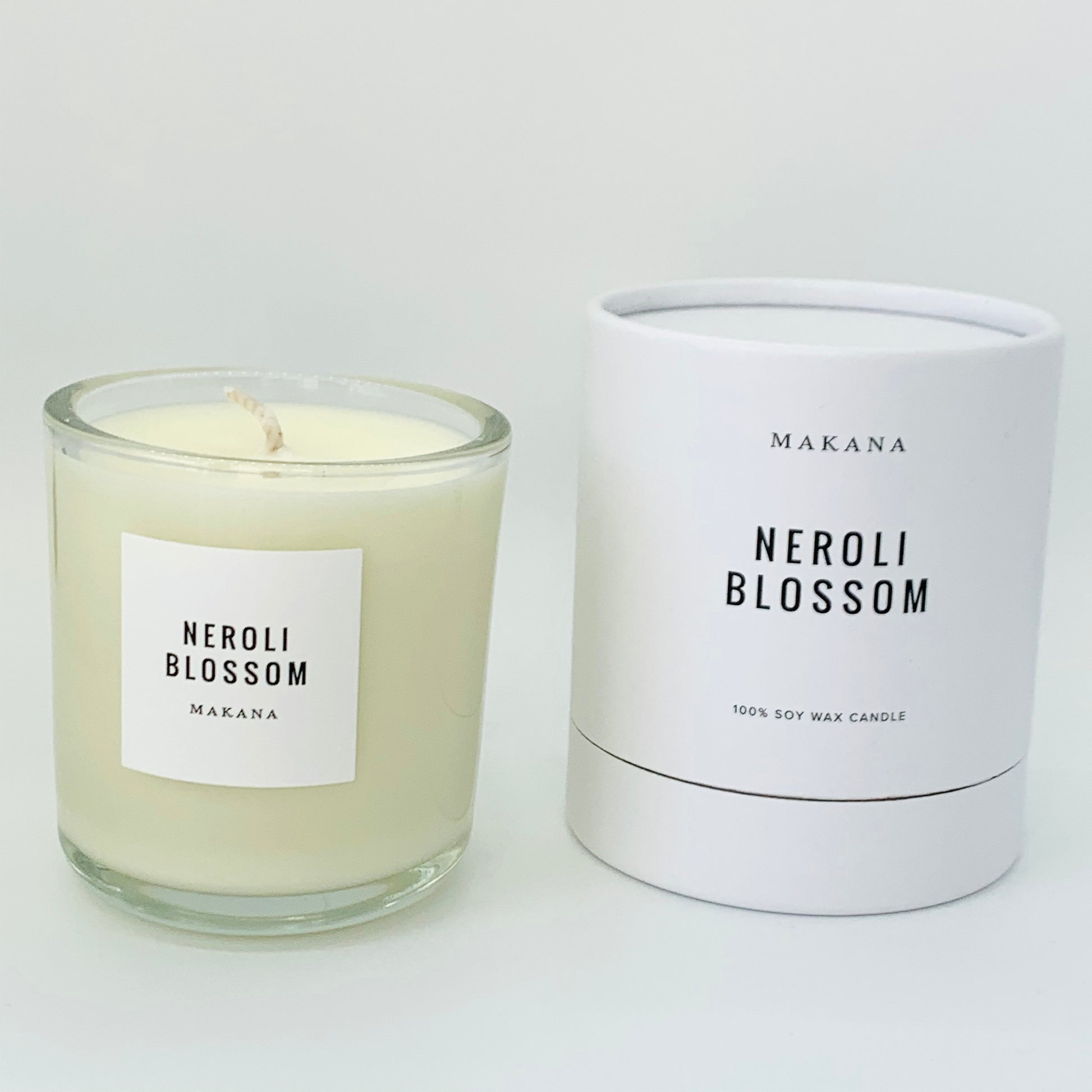 Neroli Blossom Candle = glass jar with white label black writing.  packaged candle in background