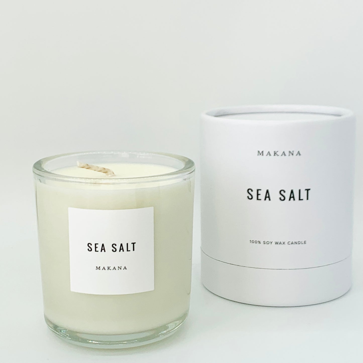Sea Salt Candle = glass jar with white label black writing.  packaged candle in background